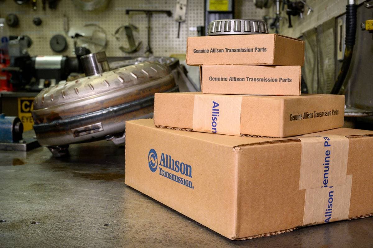 Genuine Allison Transmission parts boxes with torque converter bearing on workshop bench